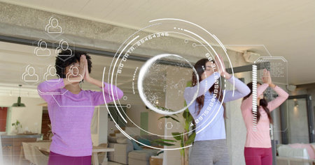Stretching three women in pastel workout wear following routine in open-plan home, AR overlay. Trio,...