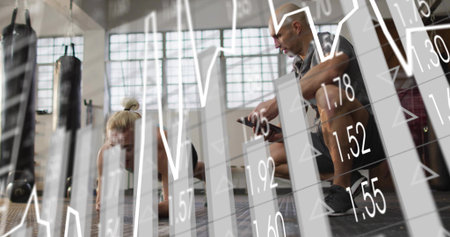 Training coach timing client doing plank in gym, wearing leggings, checking smartwatch analytics....