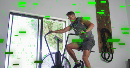 Riding man wearing sleeveless top and shorts on air fan bike in home gym, binary overlay. Cardio,...