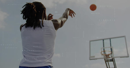 Shooting player in white tank, blue shorts following on outdoor court with basketball toward hoop....