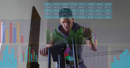 Working out green-hoodie man gripping handles, pedaling on machine in gym, with plank and charts....