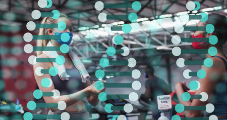 Talking masked women in gym gear gesturing listening at gym with teal partition decal and sanitizer....