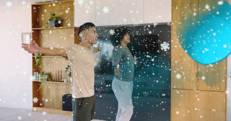 Stretching two men in loungewear in living room, with TV, shelves, blue ball, snowflake filter....