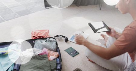 Packing man in rust tee and light pants at home, organizing passport wallet suitcase, copy space....