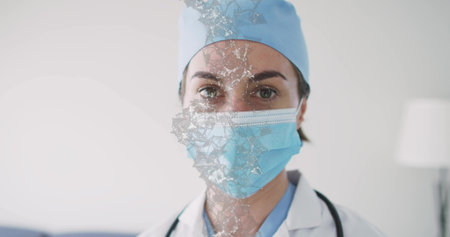 Facing doctor wearing blue cap and mask in clinic, lab coat and stethoscope, cracked mesh overlay....