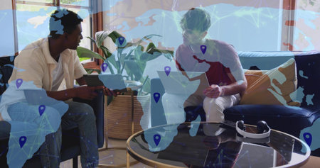 Collaborating men in polo and red T-shirt comparing tablet and laptop, living room with VR overlay....