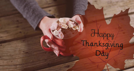 Cradling woman's hands in grey sweater holding red mug with marshmallows at table, maple greeting. Cup, cocoa, closeup, cozy, warm, autumn, thanksgivingの写真素材