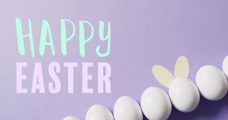 Displaying white eggs with bunny ears on pastel lavender flat-lay, showing HAPPY EASTER letters....