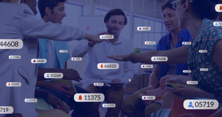 Gathering colleagues in business casual reaching into center at office huddle with tablets, badges....