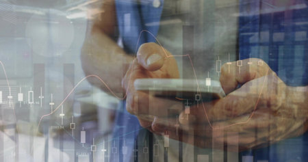 Scrolling hands wearing blue shirt viewing smartphone at office, showing candlestick charts overlay....