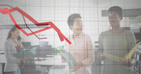 Standing three women in business wear at office discussing red downward trend on chart with folders....