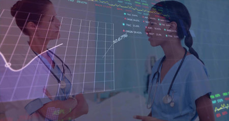 Discussing two nurses reviewing data in ward corridor with stethoscopes, blue scrubs, bed 50.67%....