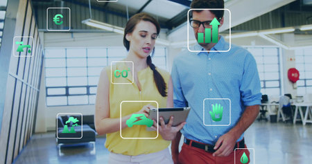 Pointing woman in yellow blouse and man with glasses discussing tablet in office, with AR overlays....