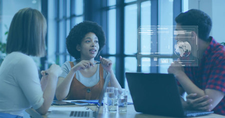 Speaking woman wearing rust dress holding pen leading meeting at modern table with laptop hologram....