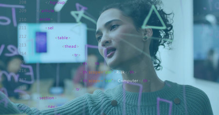 Pointing woman in knitted sweater explaining code on glass board at tech office, with markers....