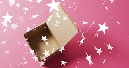 Sitting open brown corrugated cardboard box on pink paper, showing scattered white star confetti....