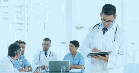Writing doctor in clinic, white coat and tie, stethoscope at right, noting clipboard, copy space....
