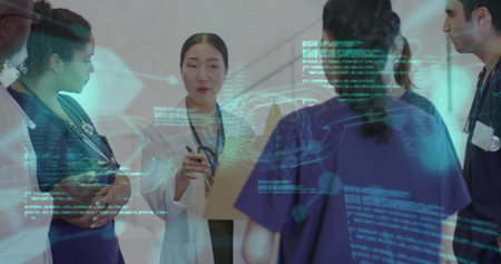 Leading clinician in white coat holding pen, tablet briefing navy scrubs team in corridor, hologram....