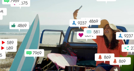 Alert arriving, woman in straw hat orange top holding phone on truck tailgate, surfboards at beach....