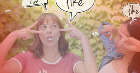 Posing two friends in red tee, blue plaid, flashing V signs in garden with speech bubbles. Duo,...