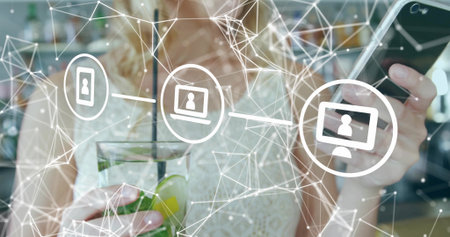 Holding glass with lime, woman wearing white lace top checking black phone at cafe, network overlay....