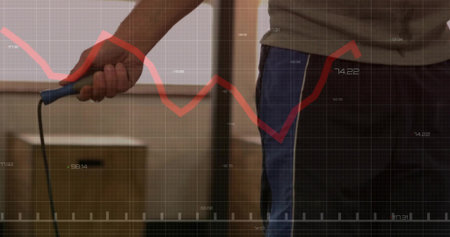 Torso holding blue-handled cord in storage, boxes, wearing olive tee and jeans, red graph overlay....