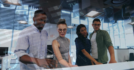 Pointing, four coworkers leaning over touch table in office, wearing shirts, gesturing at charts. Collaboration, analytics, data, dashboard, presentation, teamwork, visualizationの写真素材