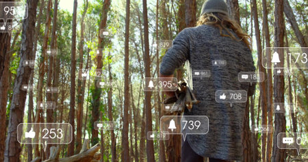 Man carrying logs walking pinewoods, movement causing floating like comment bell icons for branding....
