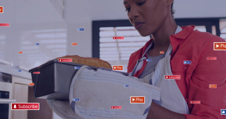 Woman wearing shirt, apron, mitt holding baked loaf pan with overlay badges in kitchen, copy space....