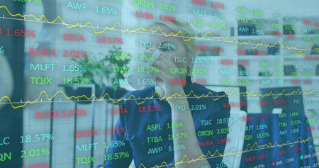 Studying senior woman in blazer in office holding tablet and pointing at glass display with tickers....