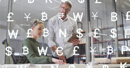 Reviewing team desk, man plaid holding tablet, woman green top pointing docs, money icons on glass....