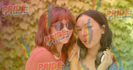Standing two women posing in garden wearing coral top plaid shirt headphones PRIDE stickers....