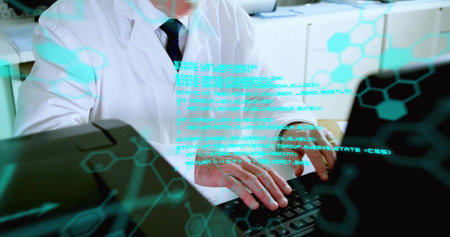 Typing researcher wearing lab coat and dark tie at lab desk using laptop with holographic code....