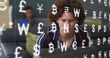Working man with curly hair wearing dark striped shirt typing on laptop in lounge, currency overlay....