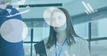 Woman in white blouse with blue lanyard showing charts in office, holding black tablet, glass panes....