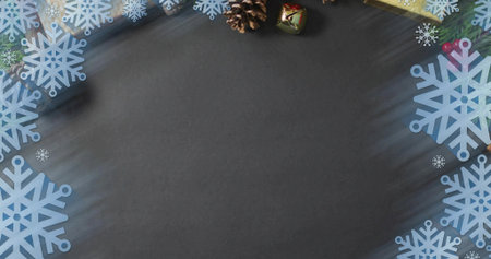 Featuring dark chalkboard center on table with blue flakes, cones, gold gift, bell, red accents. Flatlay, holiday, snowflake, border, ornaments, present, festiveの写真素材