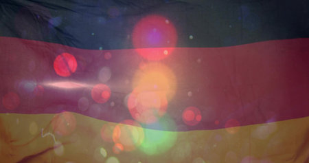 Displaying tricolor fabric flag filling frame in studio, showing wrinkles and colorful bokeh flares....