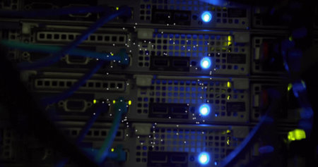 Displaying rack-mounted server blades inside server rack, showing teal Ethernet cables and LEDs....