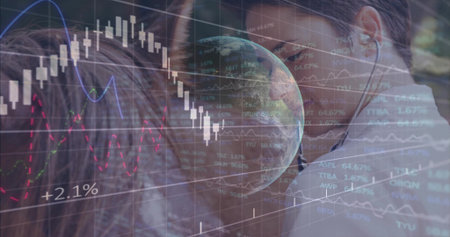 Studying woman wearing white shirt, earbud at desk, seeing stock charts and globe, copy space. Candlestick, analytics, finance, data, duo, collaboration, monitorsの写真素材