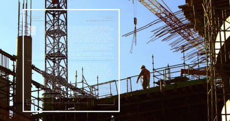 Walking site worker hardhat hi-vis vest navigating deck at building site, tower-crane, copy space....