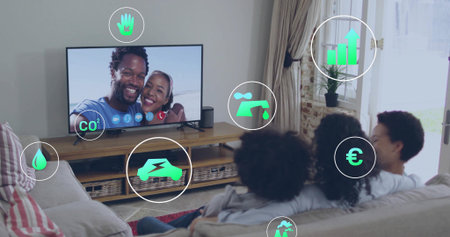Watching family wearing casual T-shirts in living room, with flat-screen TV showing green icons....