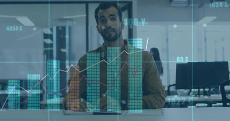 Analyzing male analyst in brown jacket reviewing tablet at open office, with turquoise graphs....