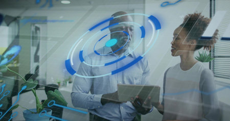 Discussing tablet content, two professionals reviewing HUD on glass near plants in office, workwear....