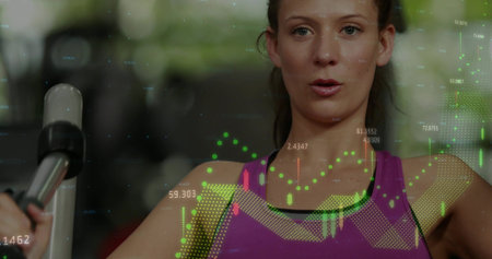 Gripping machine handle, woman in purple tank top doing strength exercise at gym with HUD overlays....