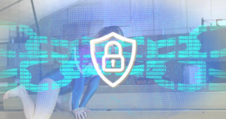 Sitting adult woman in hoodie and jeans curling on concrete steps with shield padlock overlay. Cybersecurity, privacy, digital, holographic, data, matrix, futuristicの写真素材