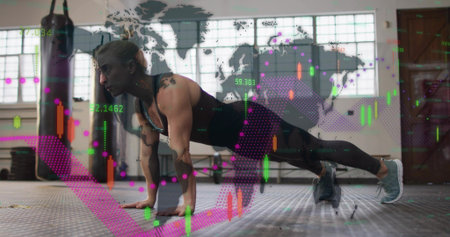 Performing woman holding plank on rubber floor, in black tank, leggings, punching bag and charts....