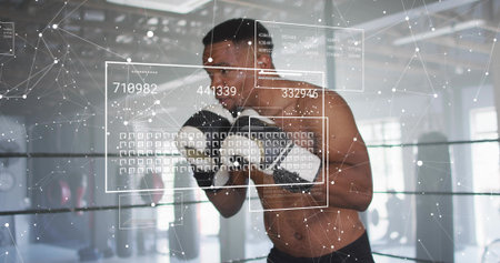 Punching bare-chested boxer delivering forward punch in boxing ring, black shorts and gloves, HUD. Athlete, fighter, gym, training, backlit, augmented, realityの写真素材