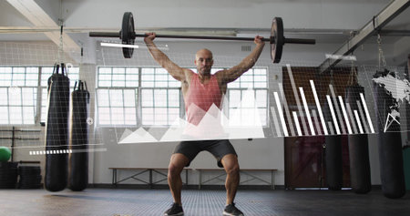 Lifting man holding barbell overhead in gym, red tank top and black shorts, with chart overlays. Weightlifting, strength, athlete, industrial, diffused, daylight, windowsの写真素材