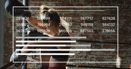 Adjusting boxer wearing black sports bra and maroon leggings tightening gloves at gym with bag, HUD. Athlete, fighter, brick, ring, glove, gritty, focusedの写真素材