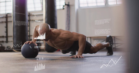Doing fit athlete pressing medicine ball one-handed on rubber mat at gym, shirtless black shorts....